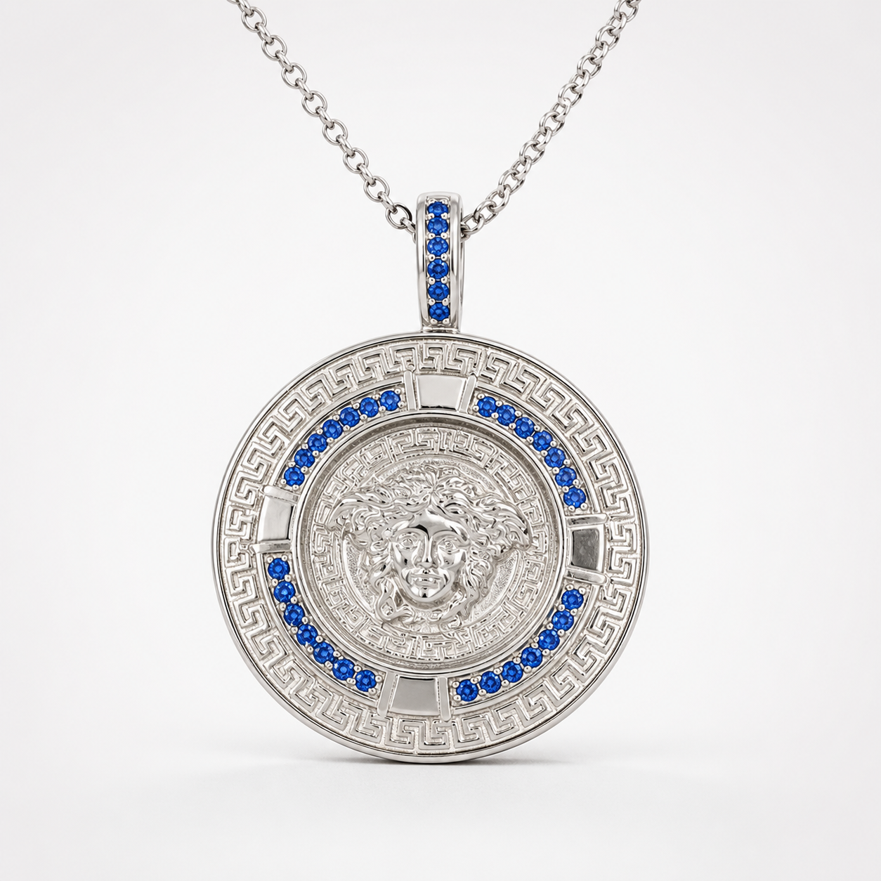 Professional studio product photo of Greek Key Mythology Medusa Pendant Blue CZ Stones + Sterling Silver Chain on white background